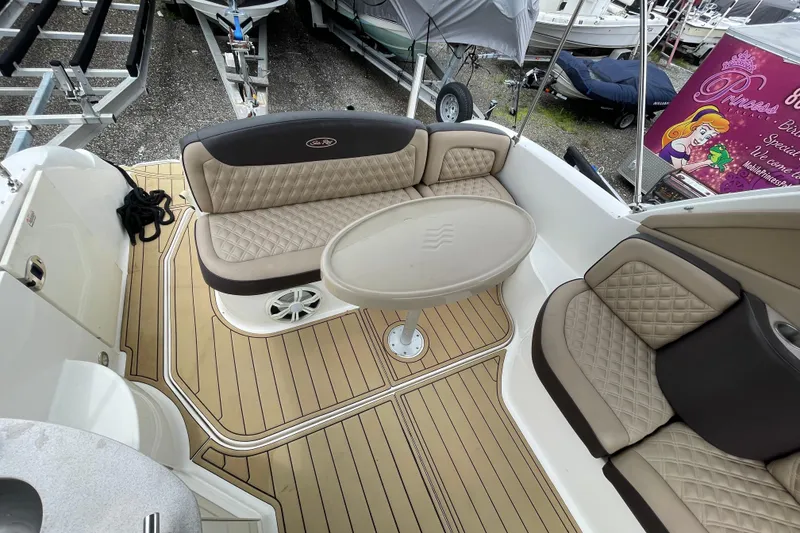 Slide: The Image of 2006 Sea Ray 290 Sundancer boat interior with beige seating and table. - 25