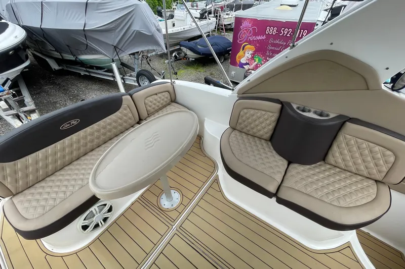 Slide: The Image of 2006 Sea Ray 290 Sundancer boat interior with beige seating and oval table. - 26