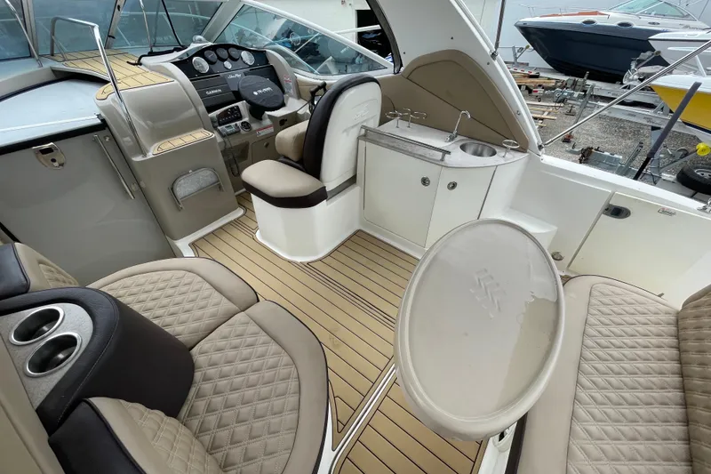 Slide: The Image of 2006 Sea Ray 290 Sundancer interior with helm, seating, and kitchenette. - 27