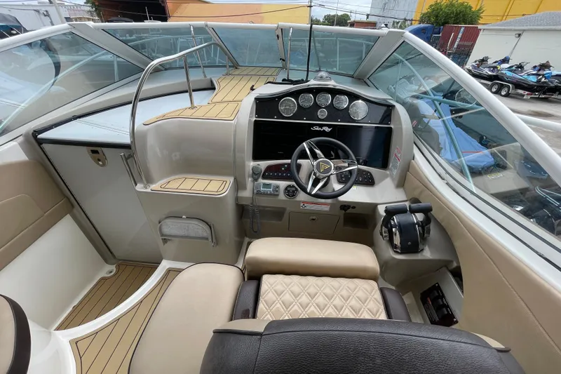 Slide: The Image of 2006 Sea Ray 290 Sundancer helm with steering wheel, gauges, and controls. - 29