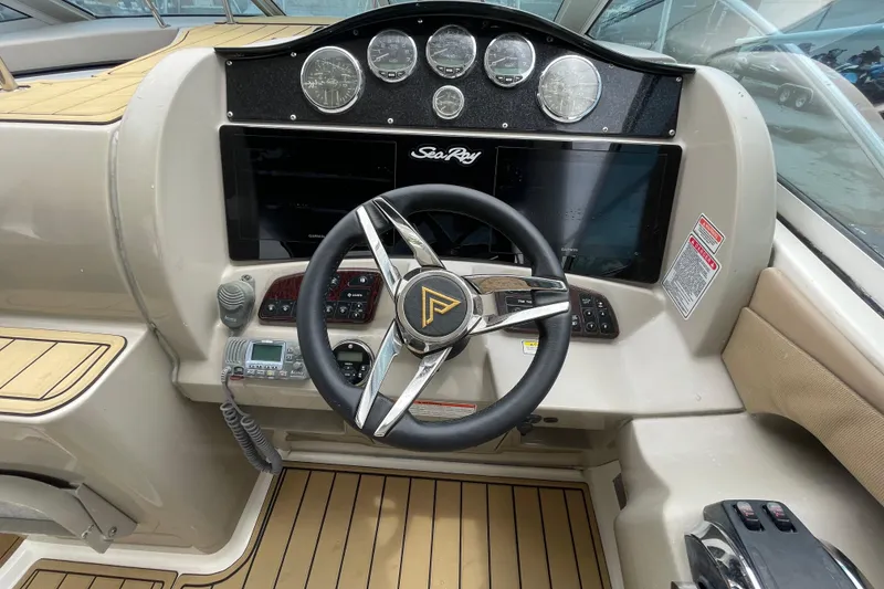 Slide: The Image of 2006 Sea Ray 290 Sundancer helm with steering wheel, gauges, and control panel. - 31