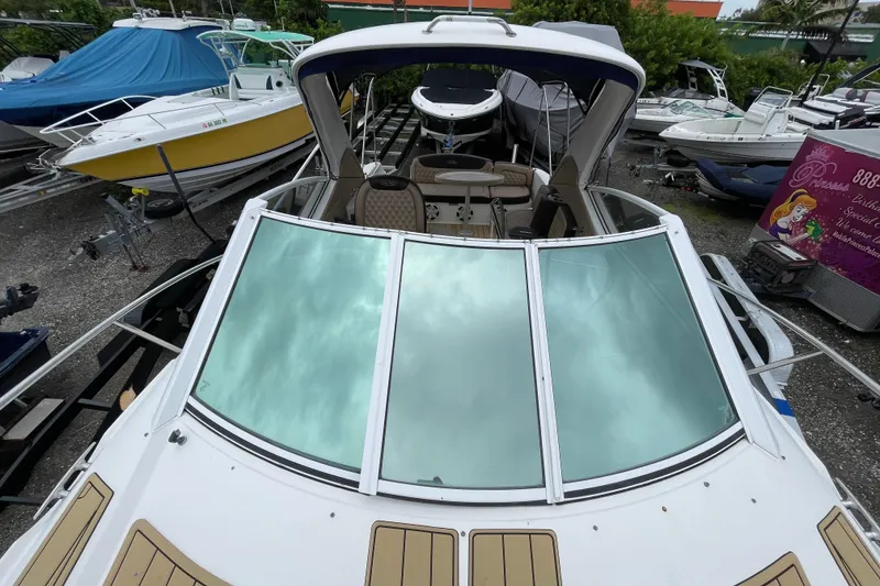 Slide: The Image of 2006 Sea Ray 290 Sundancer boat on display in a marina, surrounded by other vessels. - 35
