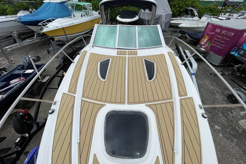 Slide: The Image of 2006 Sea Ray 290 Sundancer boat with sleek deck design in a marina setting. - 36