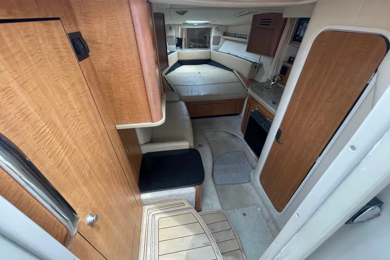 Slide: The Image of Interior of 2006 Sea Ray 290 Sundancer boat, featuring cozy cabin and kitchenette. - 39