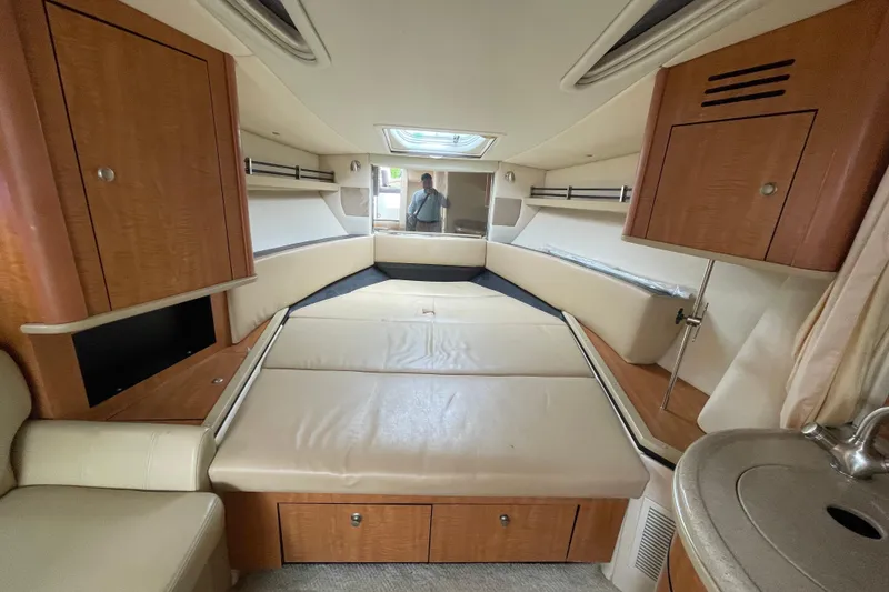 Slide: The Image of Interior cabin of 2006 Sea Ray 290 Sundancer with beige seating and wooden cabinetry. - 41
