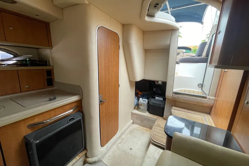 Slide: The Image of Interior of 2006 Sea Ray 290 Sundancer boat, featuring compact kitchen and seating area. - 42