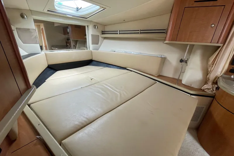 Slide: The Image of 2006 Sea Ray 290 Sundancer cabin interior with beige seating and wooden cabinetry. - 44