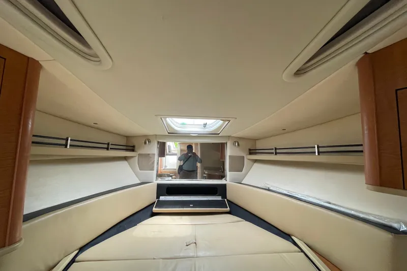 Slide: The Image of Interior cabin of 2006 Sea Ray 290 Sundancer boat, featuring beige upholstery and wood accents. - 46