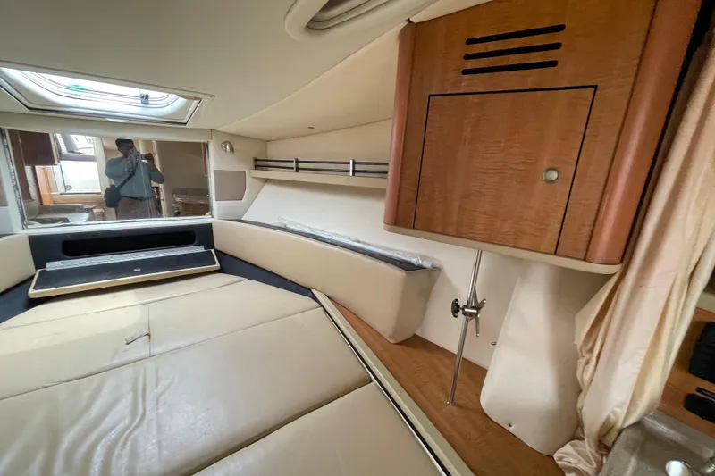 Slide: The Image of Interior cabin of 2006 Sea Ray 290 Sundancer with beige seating and wooden cabinetry. - 48