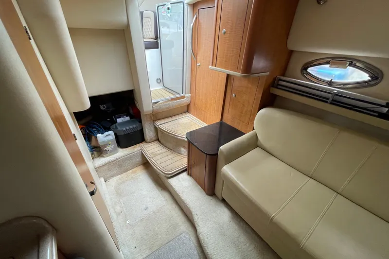 Slide: The Image of Interior of 2006 Sea Ray 290 Sundancer boat with beige seating and wooden cabinetry. - 49