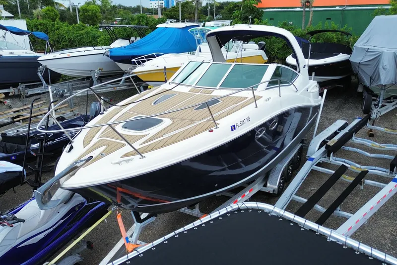 Slide: The Image of 2006 Sea Ray 290 Sundancer boat on trailer, parked among other boats. - 5