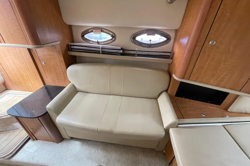 Slide: The Image of Interior of 2006 Sea Ray 290 Sundancer with beige seating and wooden cabinetry. - 50