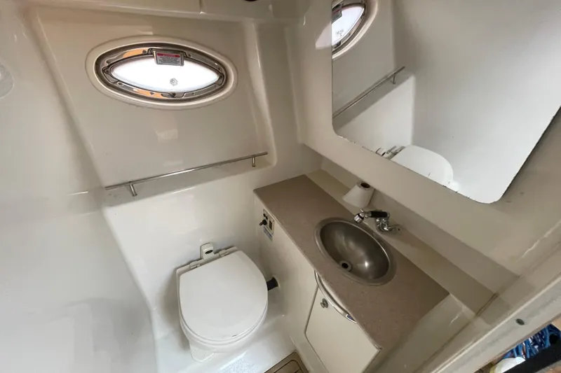 Slide: The Image of 2006 Sea Ray 290 Sundancer bathroom with sink, toilet, and mirror. - 52