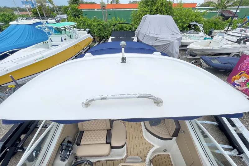 Slide: The Image of 2006 Sea Ray 290 Sundancer boat with covered cockpit, surrounded by other boats. - 55