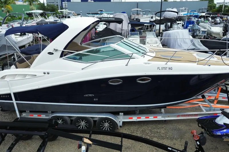 Slide: The Image of 2006 Sea Ray 290 Sundancer boat on trailer in marina setting. - 7