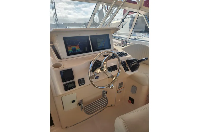 Slide: The Image of 2009 Grady-White Express 330 helm with dual screens and steering wheel. - 18