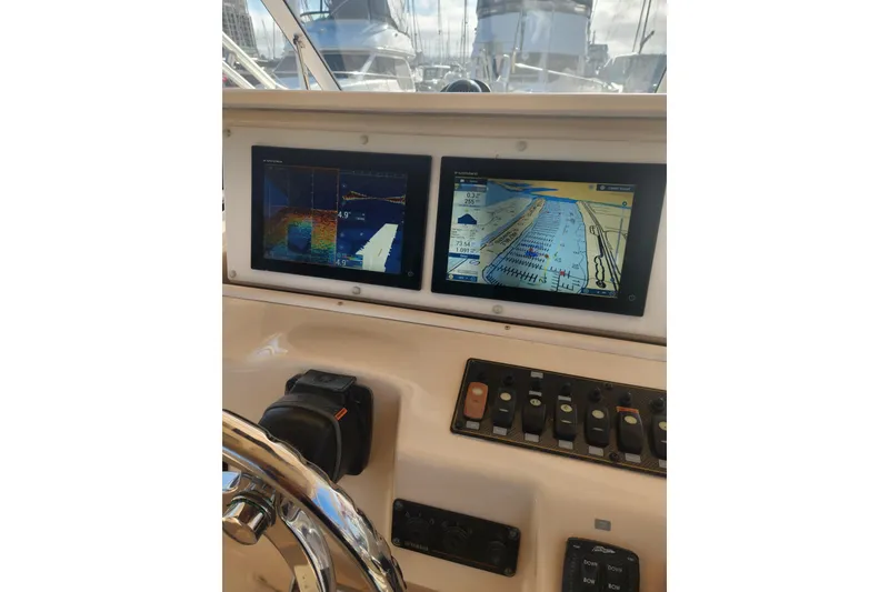 Slide: The Image of Dashboard of a 2009 Grady-White Express 330 boat with navigation screens. - 19
