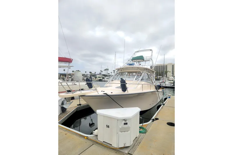 Slide: The Image of 2009 Grady-White Express 330 boat docked at marina under cloudy sky. - 2