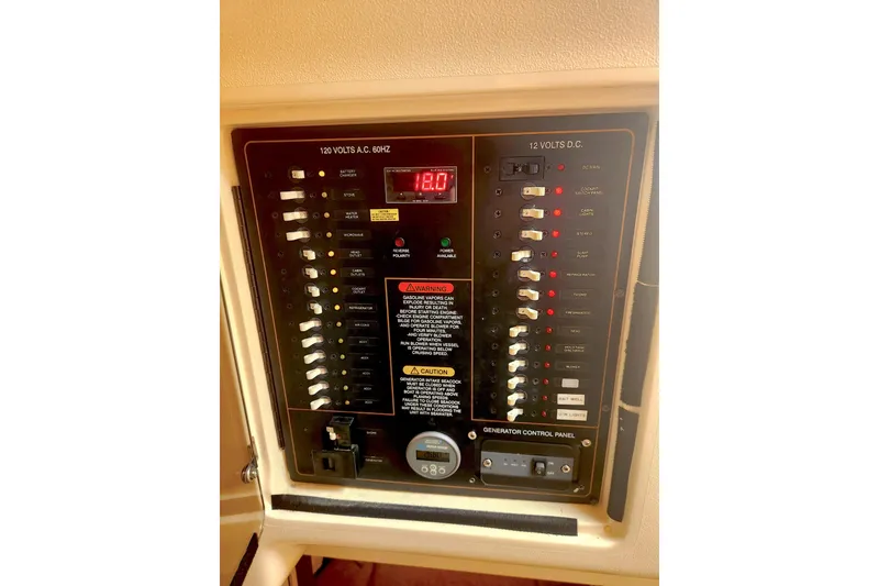 Slide: The Image of Electrical control panel on a 2009 Grady-White Express 330 boat, featuring AC and DC switches. - 23