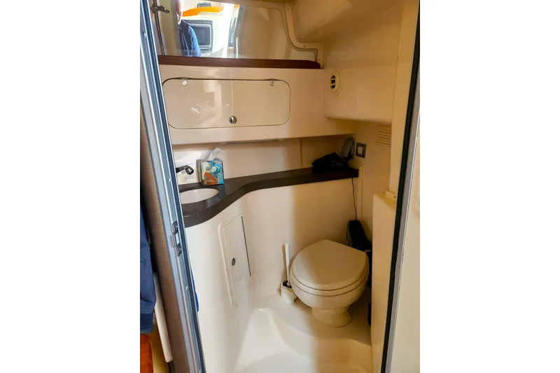 Slide: The Image of 2009 Grady-White Express 330 boat bathroom with sink, toilet, and storage cabinets. - 26