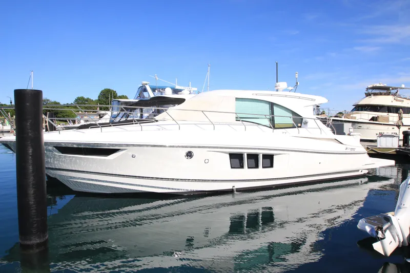 The Image of 2014 Cruisers Yachts 45 Cantius docked in a marina under clear blue skies. - 0