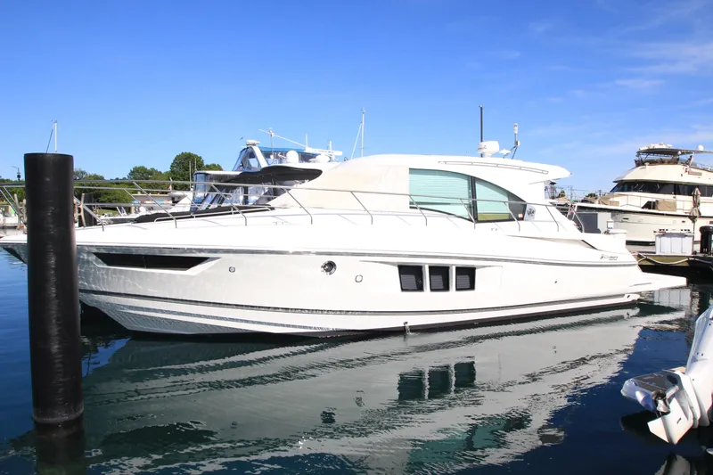 Slide: The Image of 2014 Cruisers Yachts 45 Cantius docked in a marina under clear blue skies. - 2