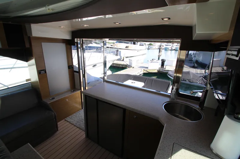 Slide: The Image of Interior view of 2014 Cruisers Yachts 45 Cantius, featuring modern kitchen and marina backdrop. - 20