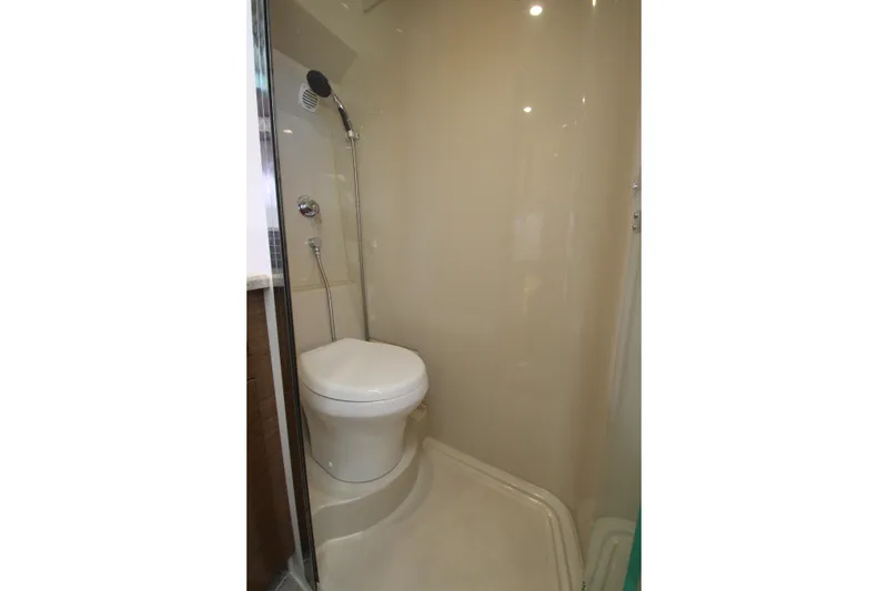 Slide: The Image of Bathroom interior of 2014 Cruisers Yachts 45 Cantius, featuring a compact shower and toilet. - 54