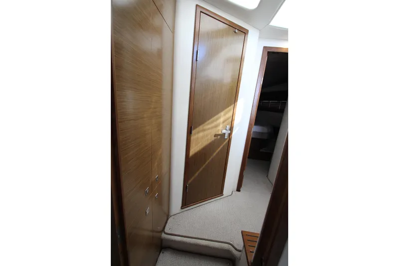 Slide: The Image of Interior hallway of 2014 Cruisers Yachts 45 Cantius, featuring wooden doors and carpeted flooring. - 69