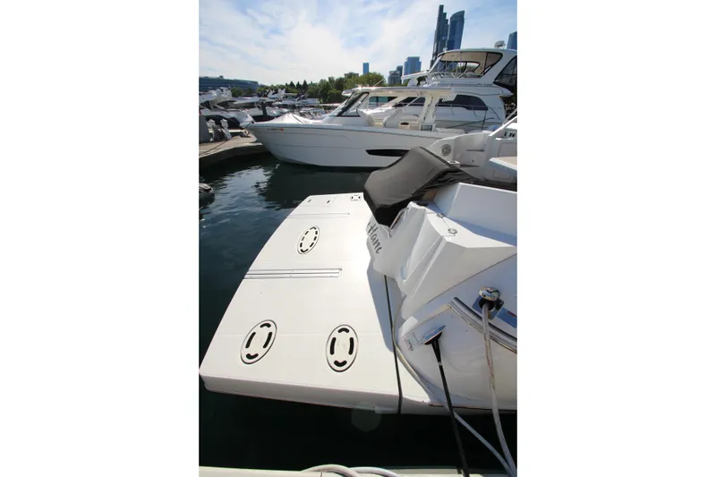 Slide: The Image of 2014 Cruisers Yachts 45 Cantius docked at marina, showcasing sleek design and spacious deck. - 82