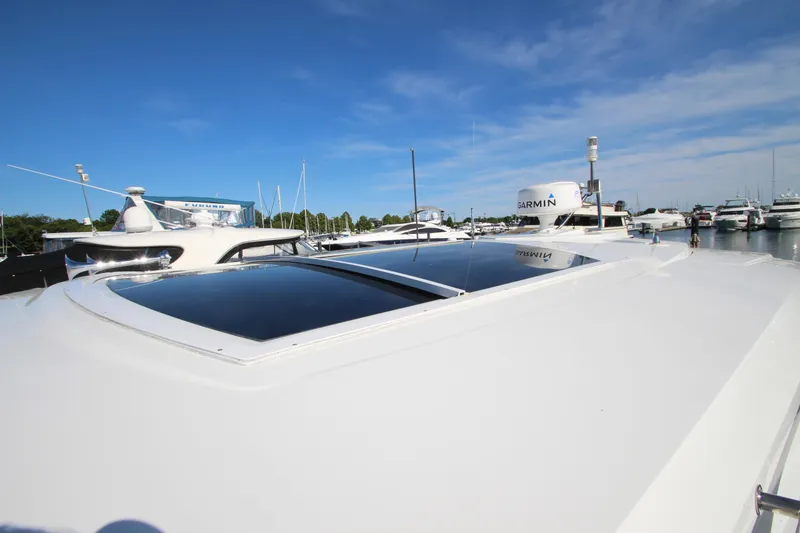 Slide: The Image of 2014 Cruisers Yachts 45 Cantius with sunroof, docked in a marina under clear blue skies. - 85
