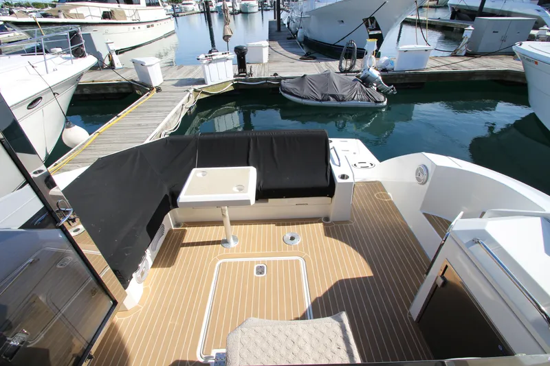 Slide: The Image of 2014 Cruisers Yachts 45 Cantius cockpit with seating and table, docked at marina. - 9
