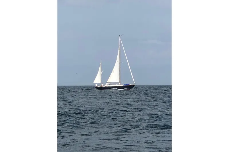 Slide: The Image of 1970 Hinckley Bermuda 40 sailboat navigating open sea under clear skies. - 10