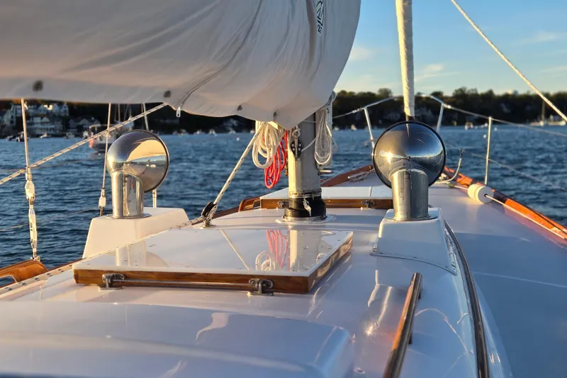 Slide: The Image of Hinckley Bermuda 40 sailboat deck, 1970 model, sailing on a sunny day with scenic background. - 101