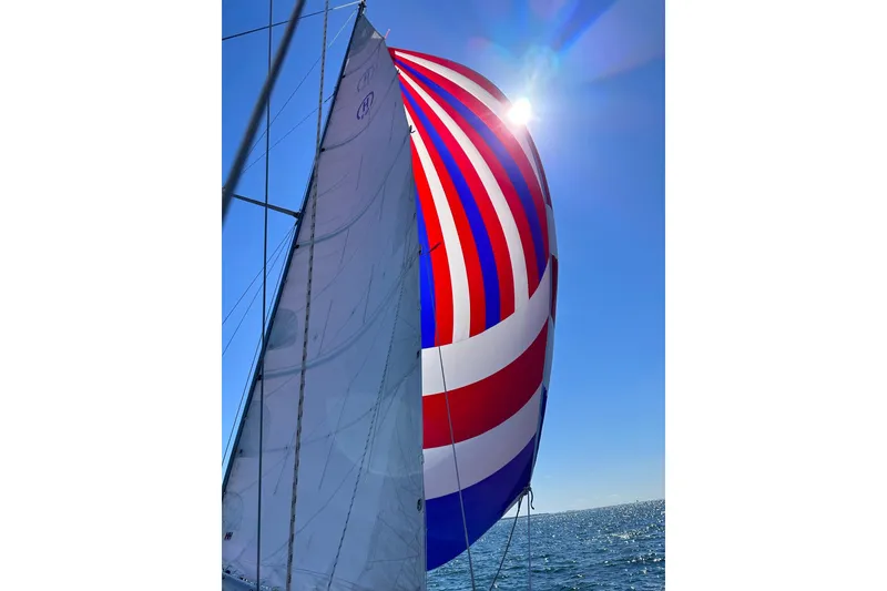 Slide: The Image of Sailing yacht Hinckley Bermuda 40 with colorful spinnaker against clear blue sky. - 11