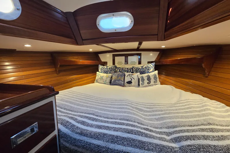 Slide: The Image of Cozy cabin interior of 1970 Hinckley Bermuda 40 sailboat with wooden paneling and plush bedding. - 111