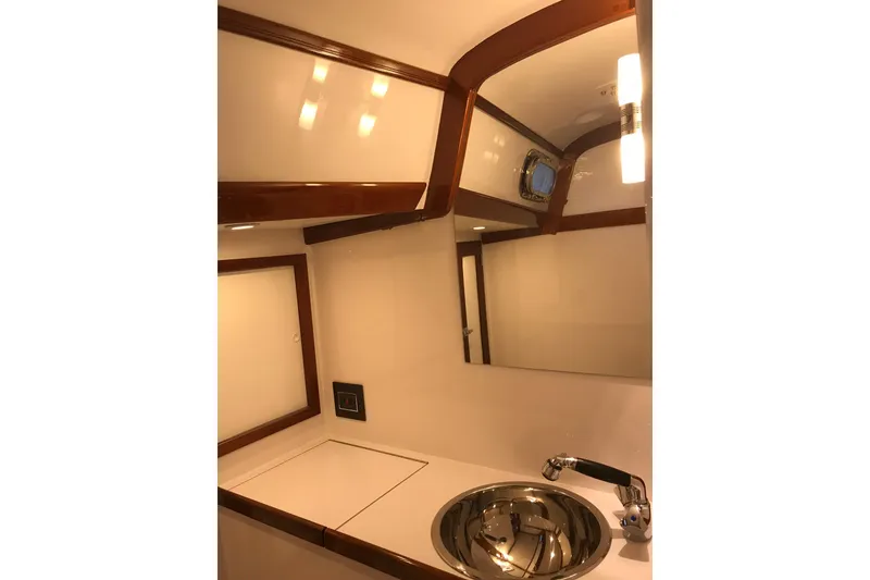 Slide: The Image of Hinckley Bermuda 40 yacht bathroom interior, featuring a sleek sink and elegant wood accents. - 12