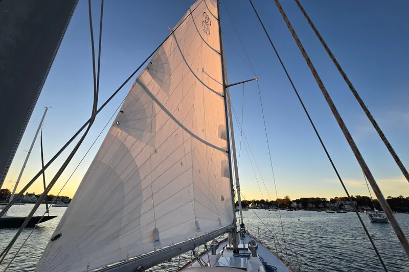 Slide: The Image of Sailing on a 1970 Hinckley Bermuda 40 at sunset, showcasing its majestic sails. - 121