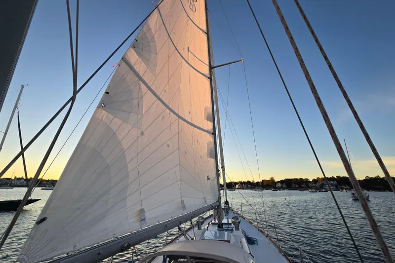 Slide: The Image of Sailing on a 1970 Hinckley Bermuda 40 at sunset, calm waters, clear sky. - 122