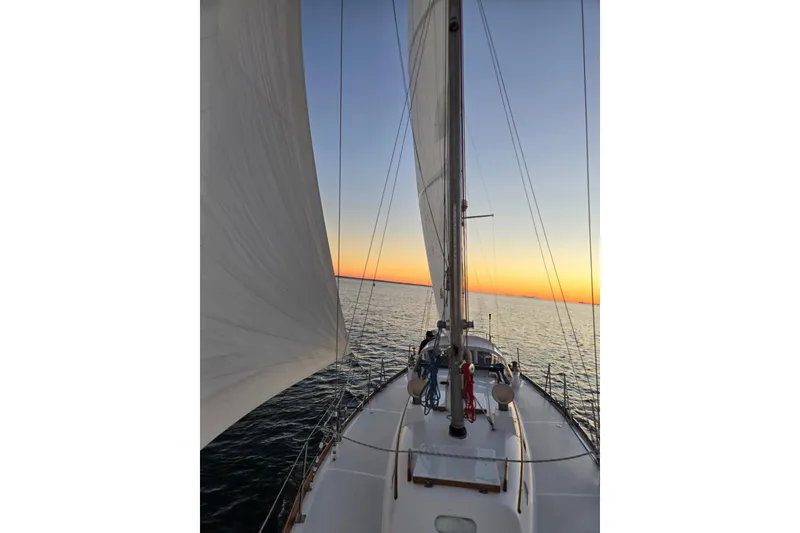 Slide: The Image of Sailing on a 1970 Hinckley Bermuda 40 at sunset, calm sea and vibrant sky. - 127