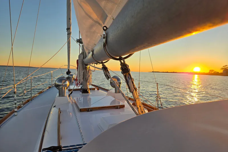 Slide: The Image of 1970 Hinckley Bermuda 40 sailboat at sunset on calm waters. - 128