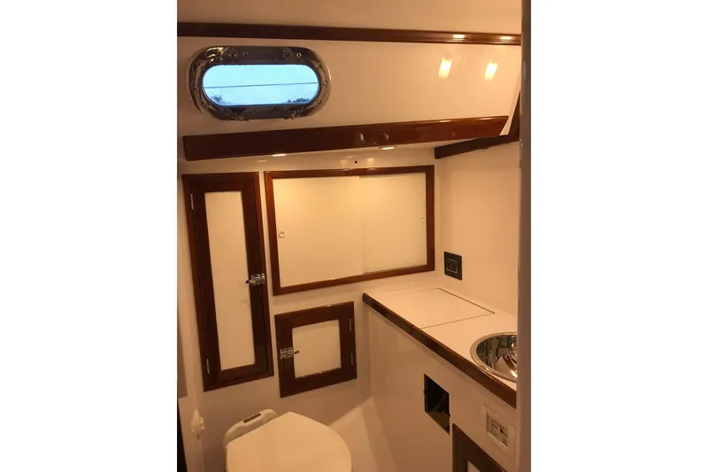 Slide: The Image of Interior of 1970 Hinckley Bermuda 40 yacht bathroom with wooden accents and porthole window. - 13