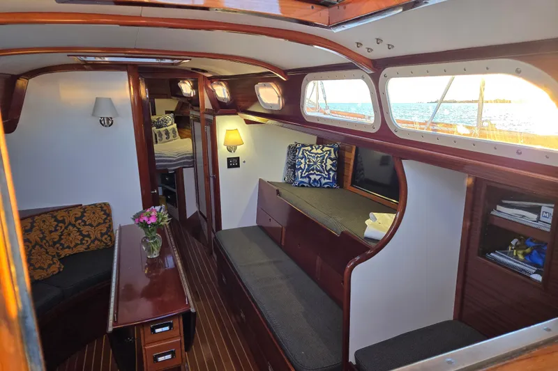 Slide: The Image of Interior of a 1970 Hinckley Bermuda 40 sailboat, featuring elegant woodwork and cozy seating. - 130