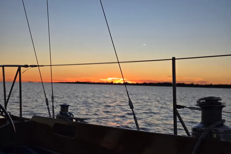 Slide: The Image of Sailing on a 1970 Hinckley Bermuda 40 at sunset over calm waters. - 140