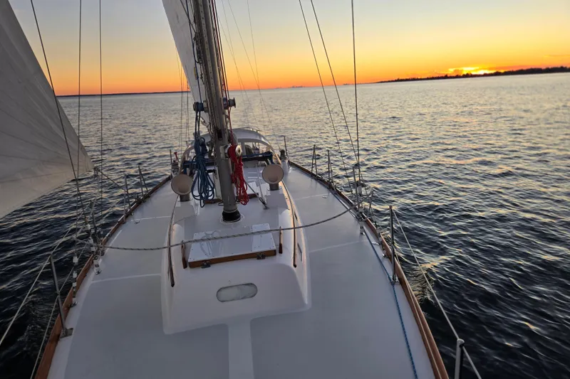 Slide: The Image of Hinckley Bermuda 40 sailboat on calm waters at sunset, 1970 model. - 141