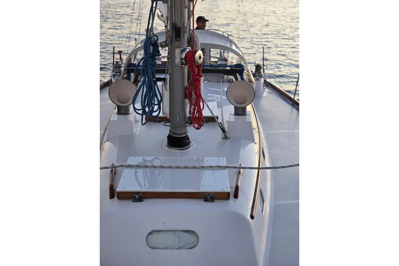 Slide: The Image of 1970 Hinckley Bermuda 40 sailboat deck with ropes and mast, sailing on calm waters. - 142