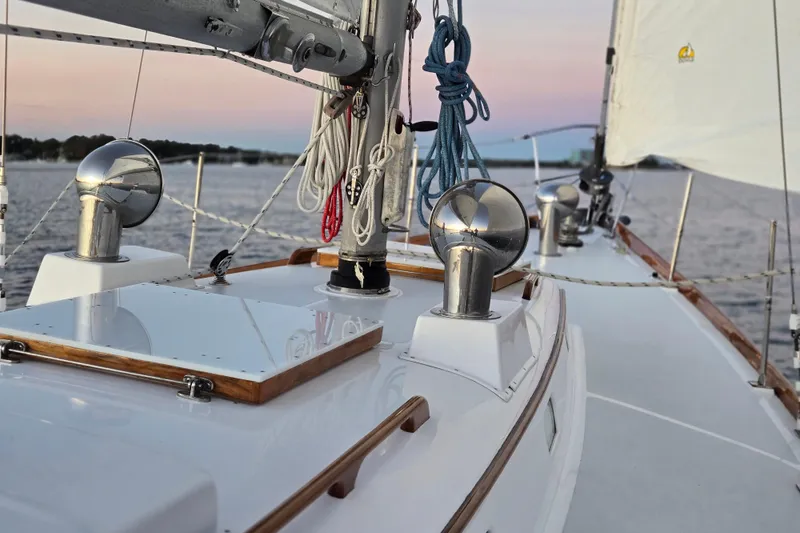Slide: The Image of 1970 Hinckley Bermuda 40 sailboat deck with ropes and fittings at sunset. - 145