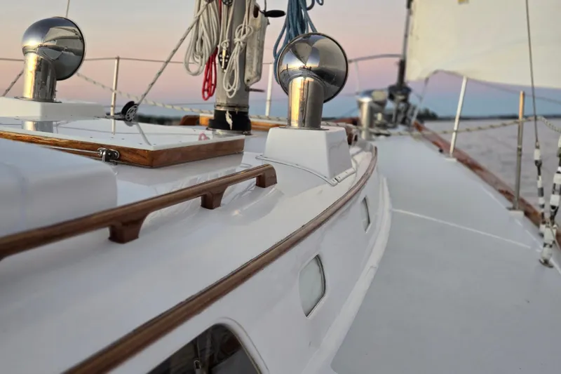 Slide: The Image of 1970 Hinckley Bermuda 40 sailboat deck with ropes and polished fittings at sunset. - 146