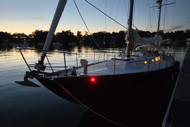 Slide: The Image of 1970 Hinckley Bermuda 40 sailboat docked at sunset, reflecting on calm water. - 148