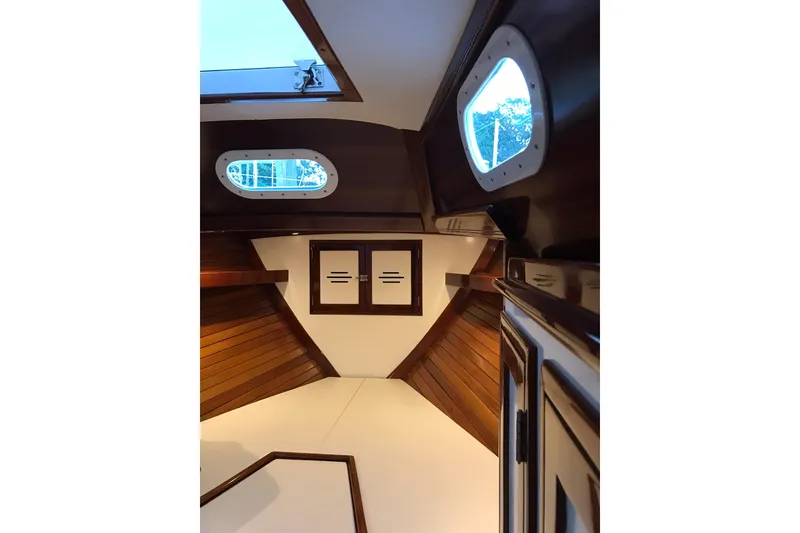 Slide: The Image of Interior of a 1970 Hinckley Bermuda 40 sailboat, featuring wooden paneling and portholes. - 15